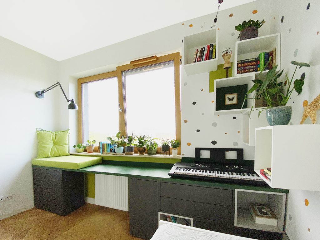 pokoj dzieciecy, drewniane biurko, czarne szafki, pianino, rosliny