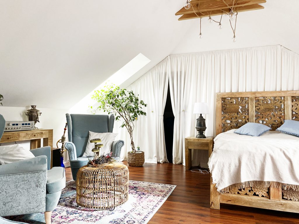sypialnia, drewniane lozko, szare fotele, perski dywan,