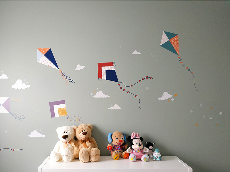 zabawki na bialej szafce na tle tapety w latawce w pokoju dzieciecym